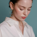 A pair of gold-filled hoop earrings with aquamarine crystals.