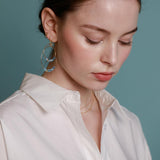 A pair of gold-filled hoop earrings with aquamarine crystals.