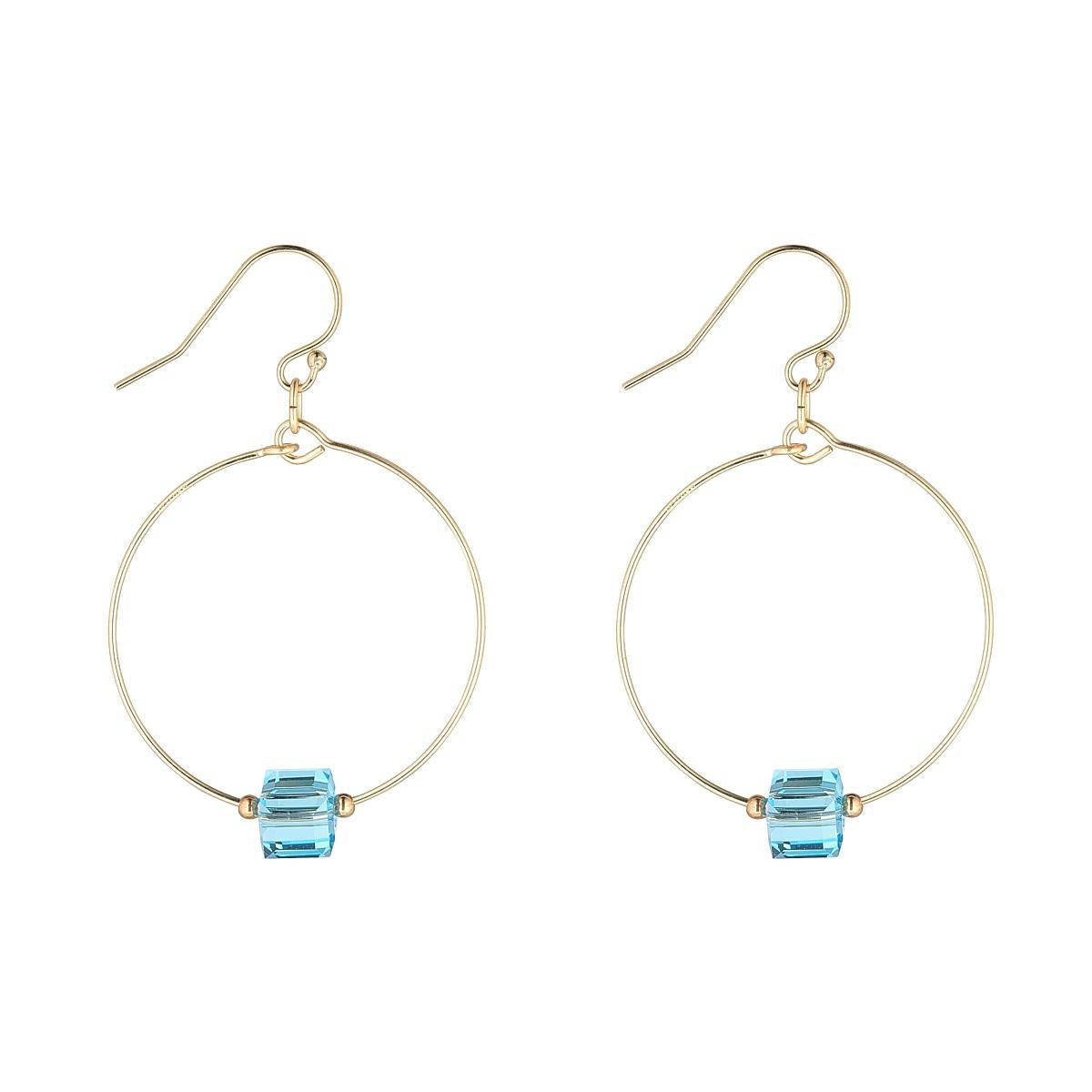 A pair of gold filled hoop earrings with blue aquamarine crystal cubes attached to the hoops.
