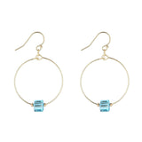 A pair of gold filled hoop earrings with blue aquamarine crystal cubes attached to the hoops.
