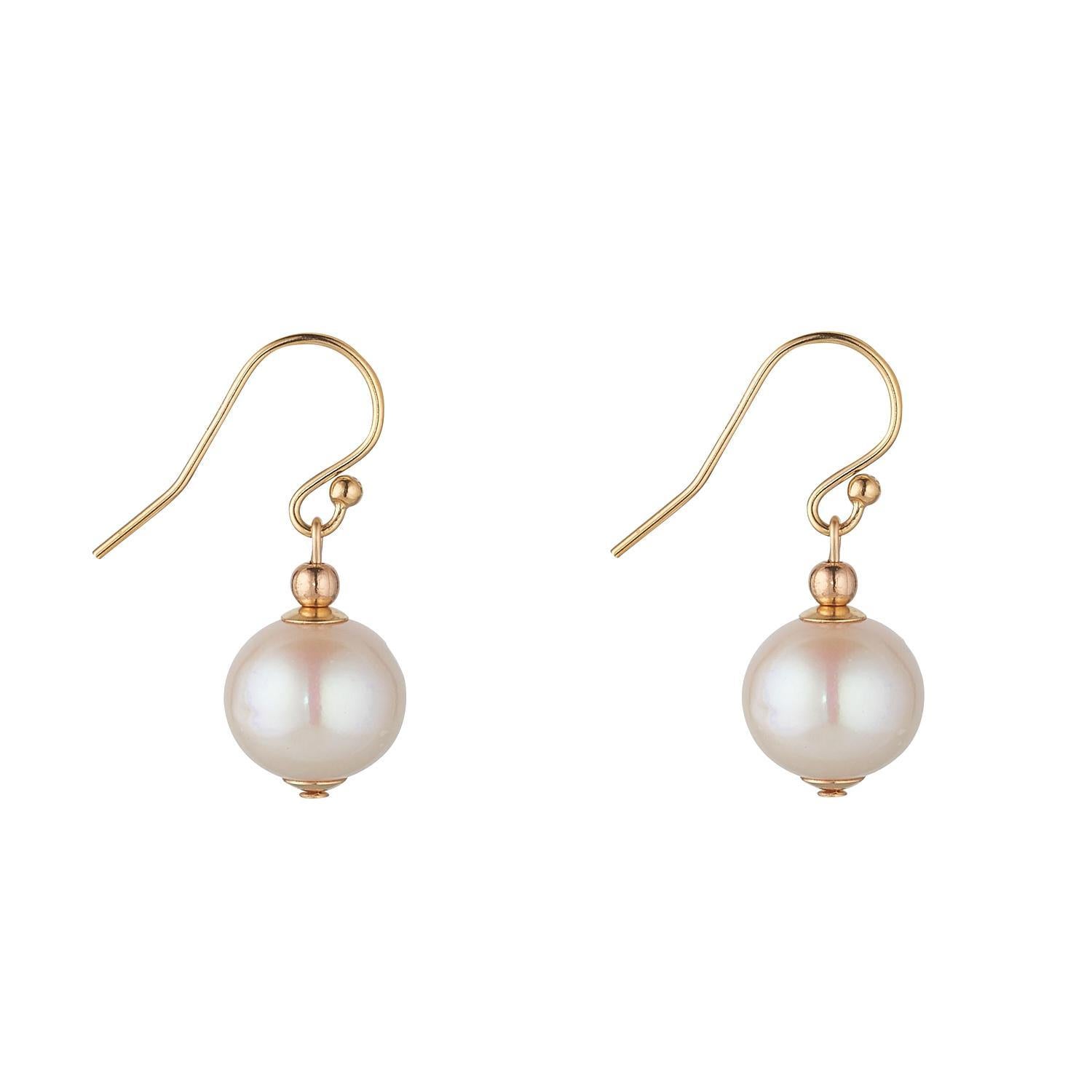 A pair of gold filled earrings featuring a single fresh water pearl drop.