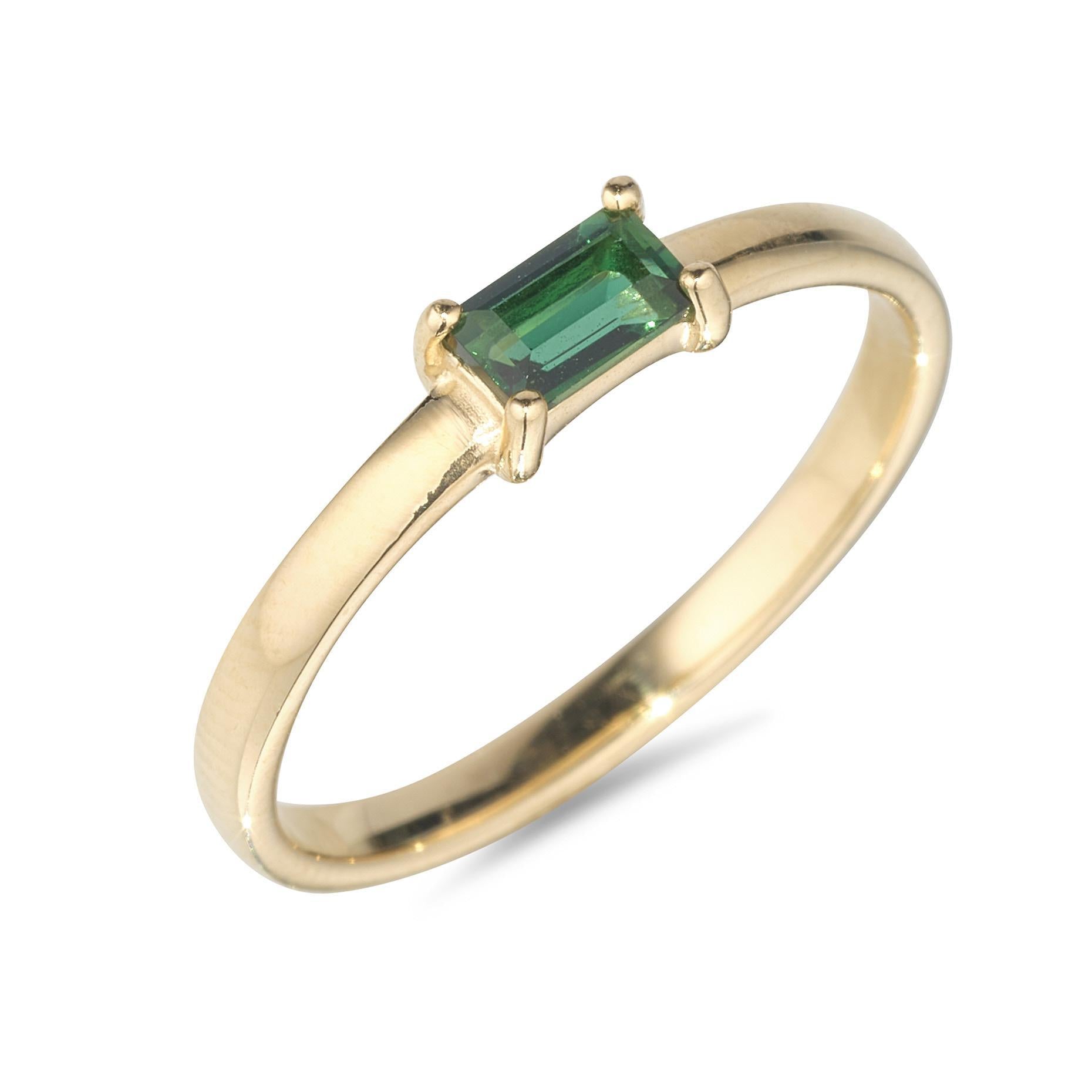 A 9kt yellow gold ring with a green quartz baguette centerpiece.