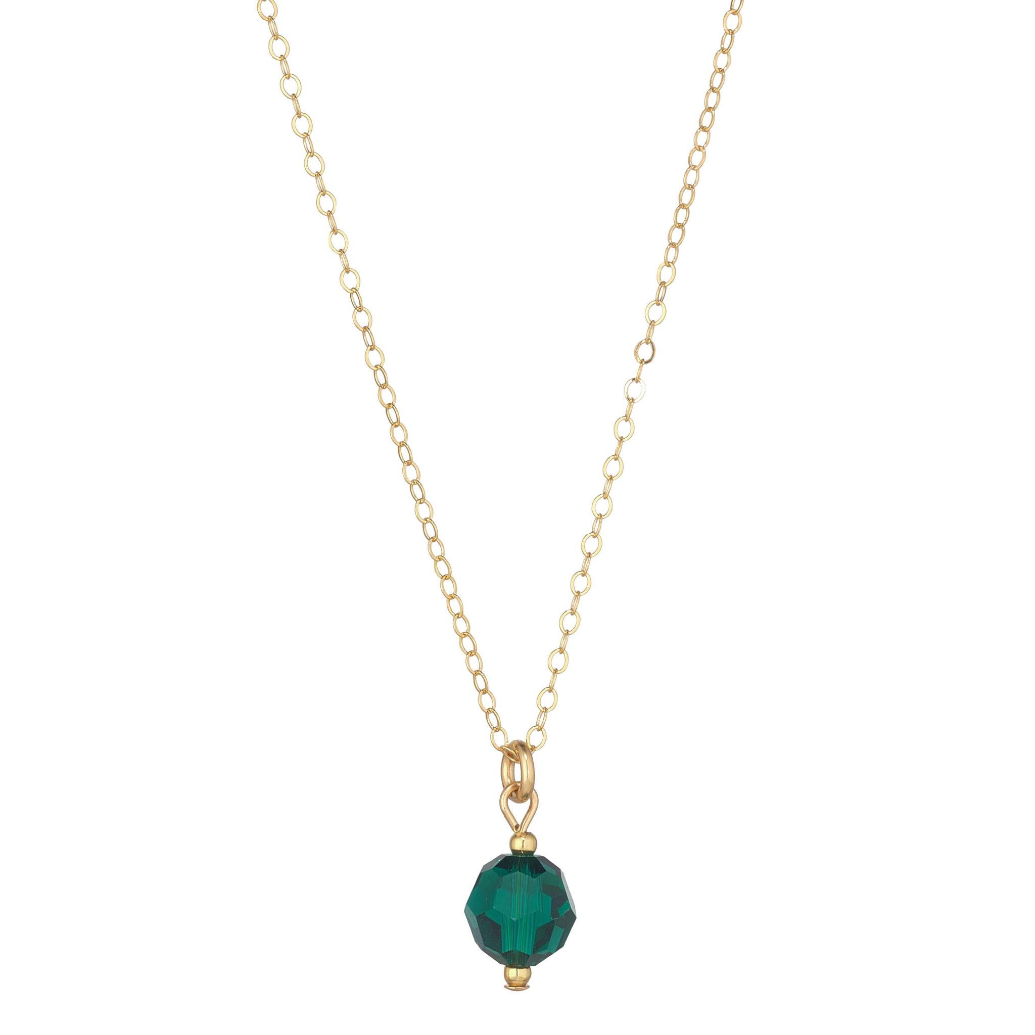 A gold filled necklace with an emerald green crystal globe pendant.
