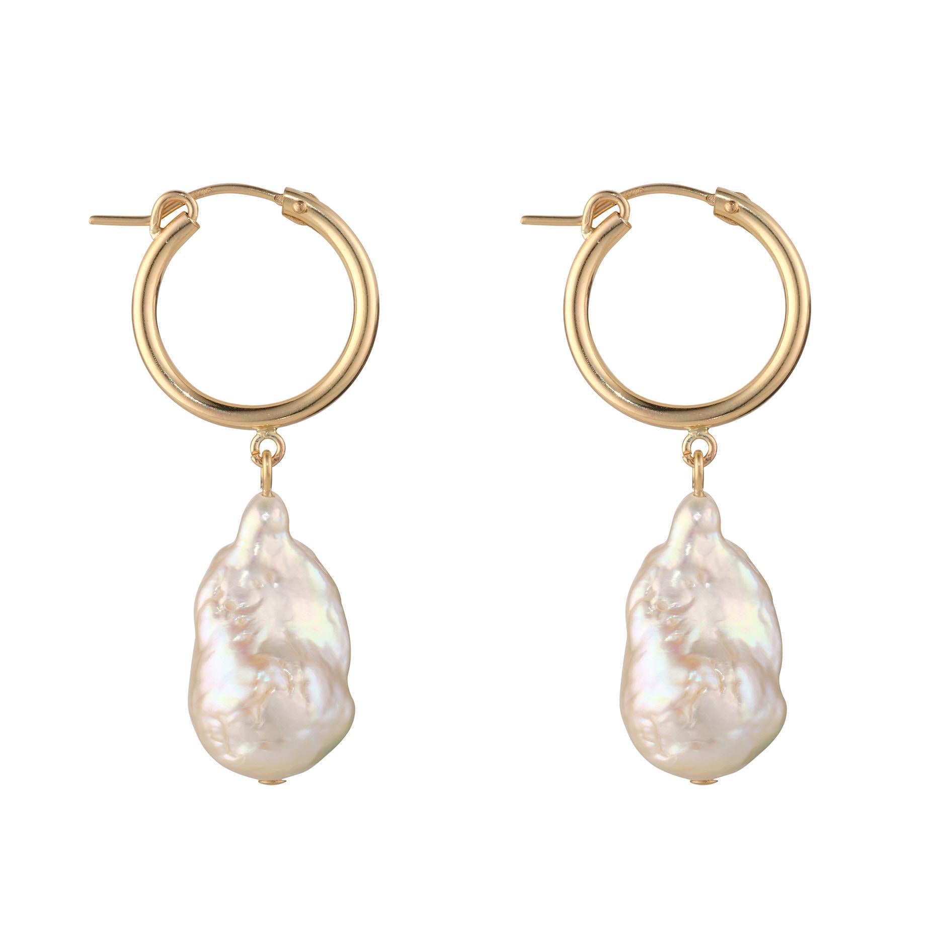 A pair of gold-filled clip hoop earrings with large baroque pearls attached.