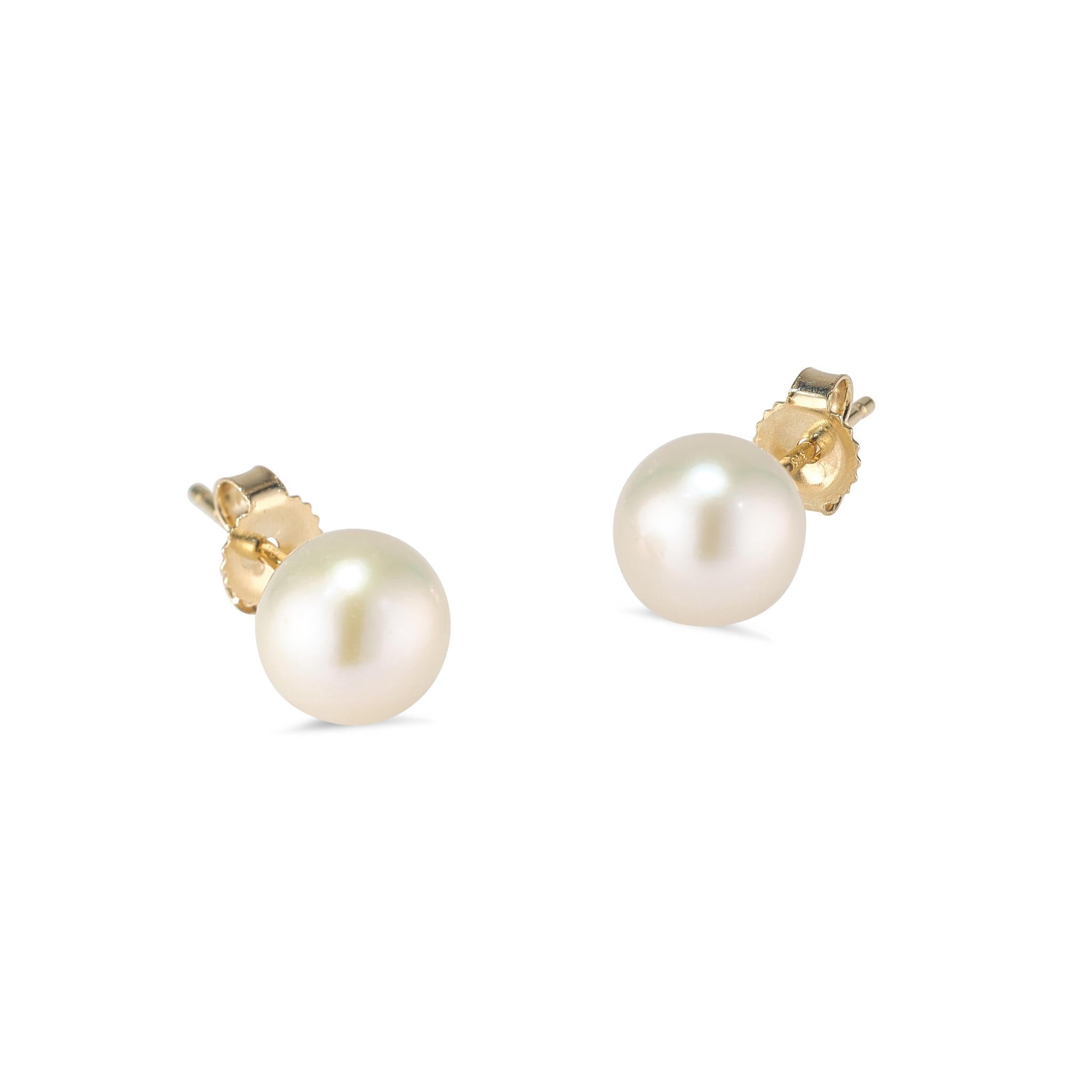 A pair of 9kt yellow gold stud earrings with round freshwater pearls.