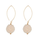 Pair of cream crystal drop earrings with gold hooks on a white background