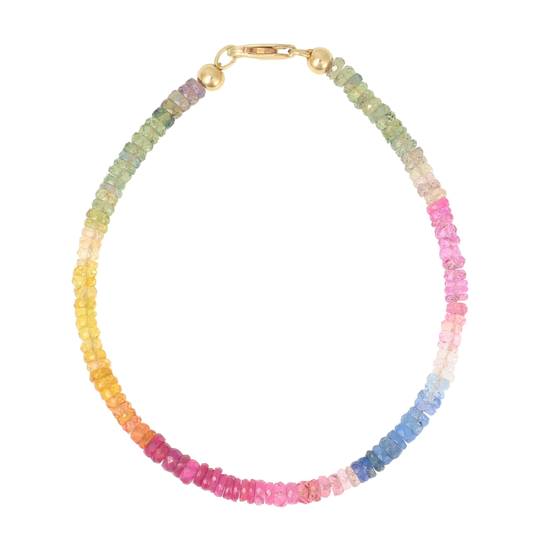 Multicolored sapphire bracelet with a gold clasp on a white background