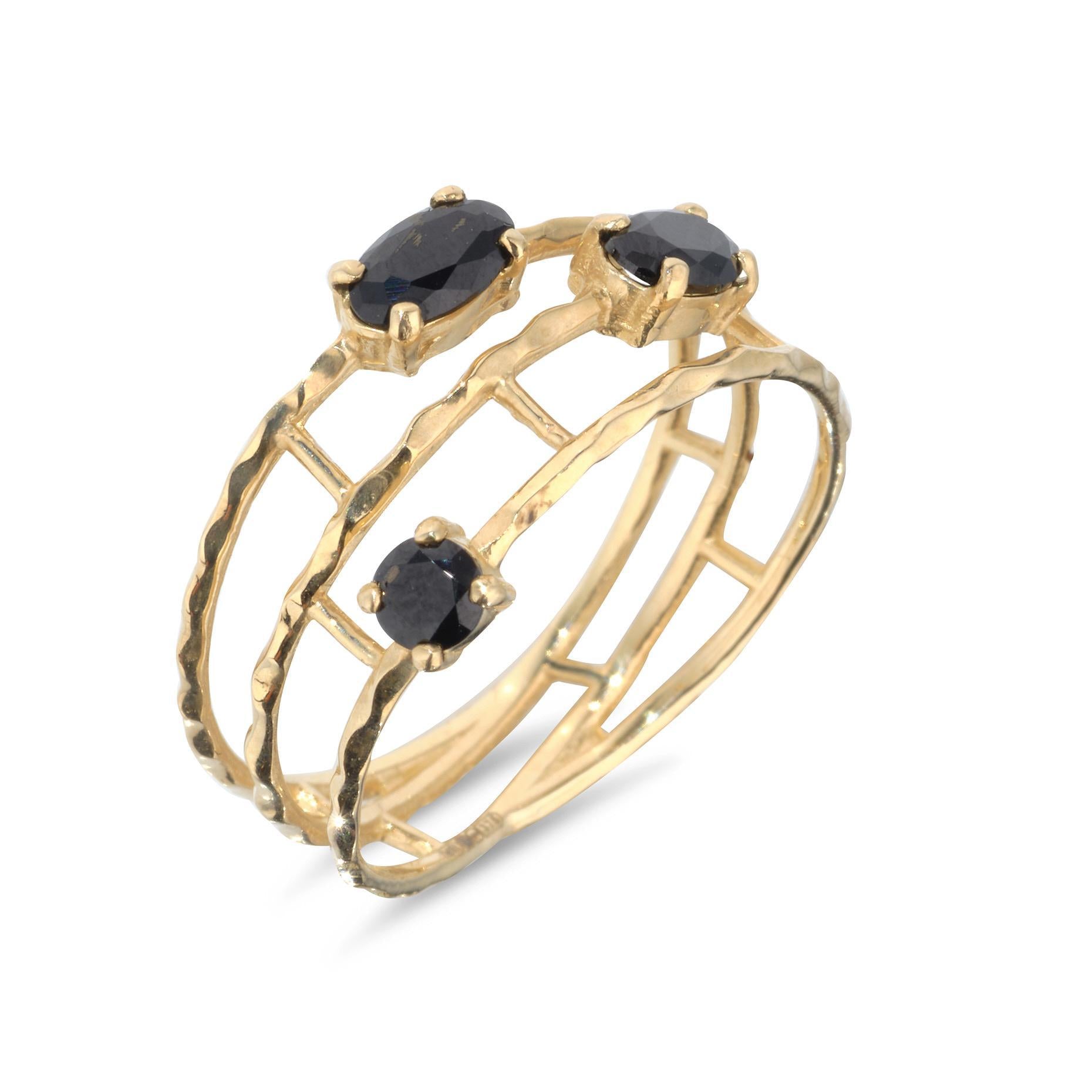 A 9kt gold ring with a layered wire design featuring three black spinel gemstones.