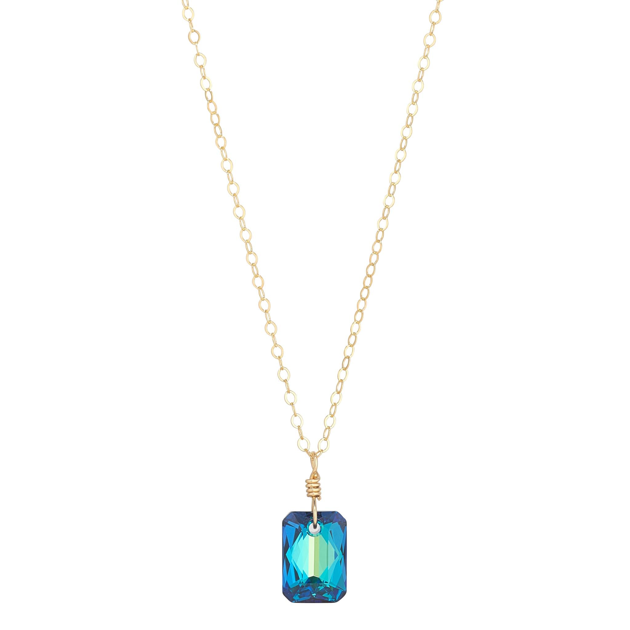 A gold filled chain necklace with a Bermuda Blue, emerald cut crystal pendant.