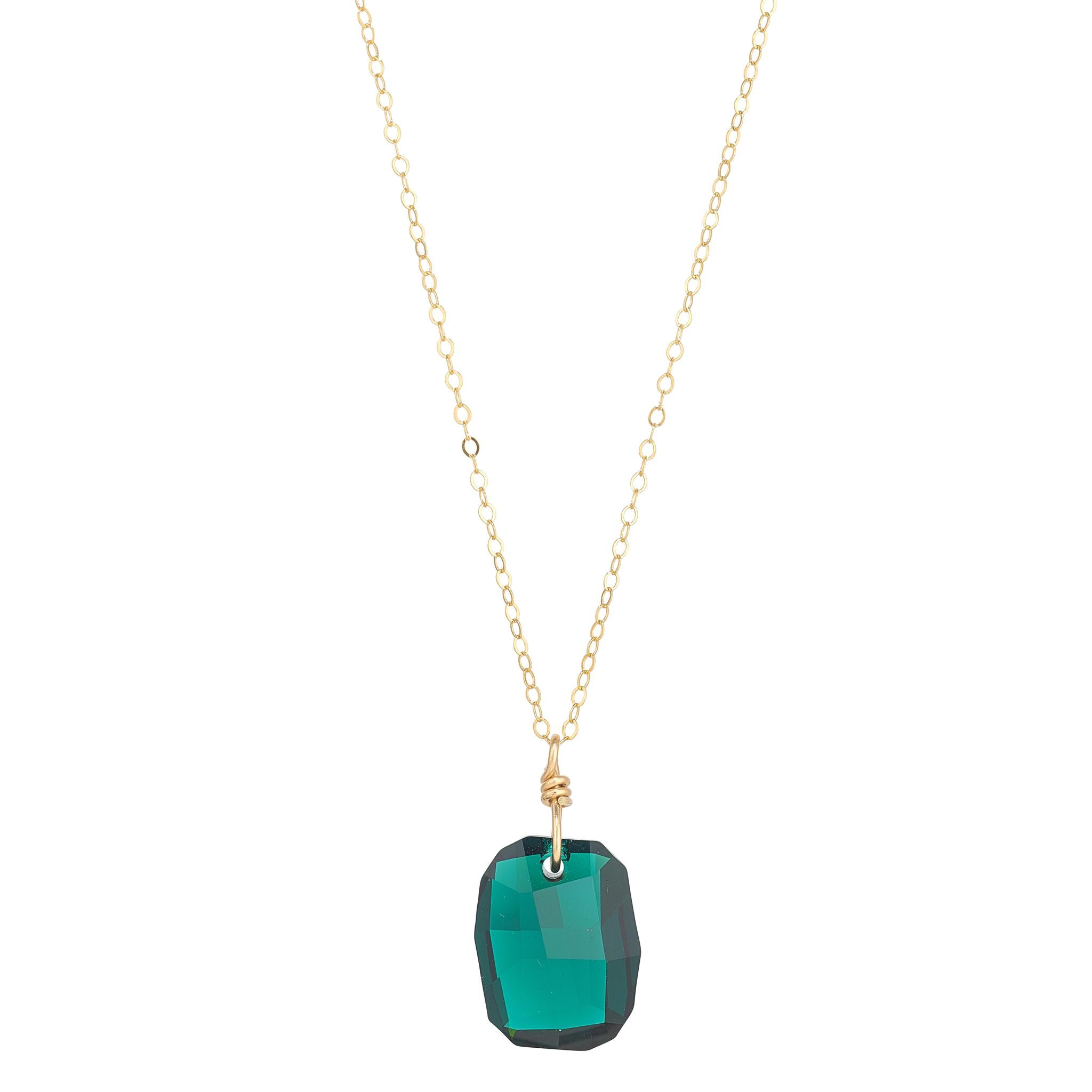 A gold filled chain necklace with an emerald green, emerald cut crystal pendant.