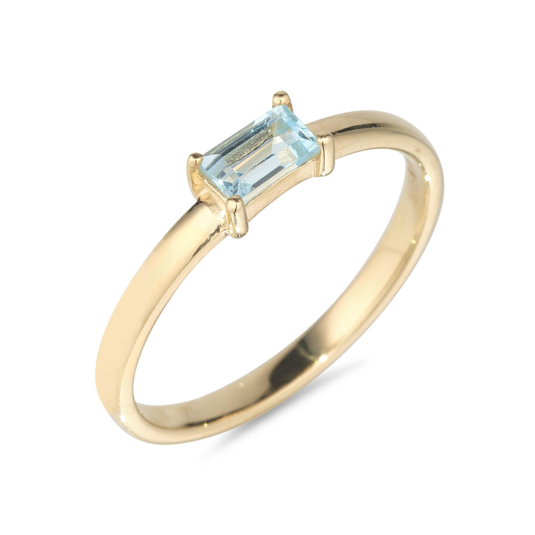 A 9kt yellow gold ring with a sky blue topaz baguette cut stone set in a gold band.