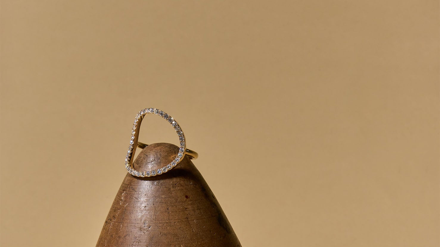 Two diamond rings on a brown surface with a wooden object in the background