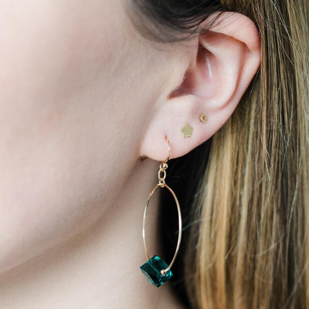 A pair of gold filled small hoop earring with a green crystal cube.
