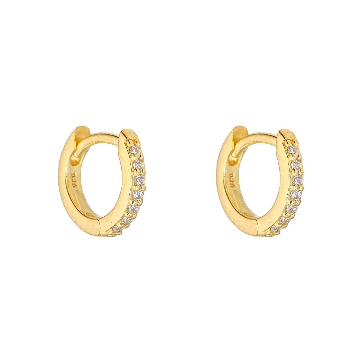 A pair of gold plated huggie earrings adorned with cubic zirconia stones.