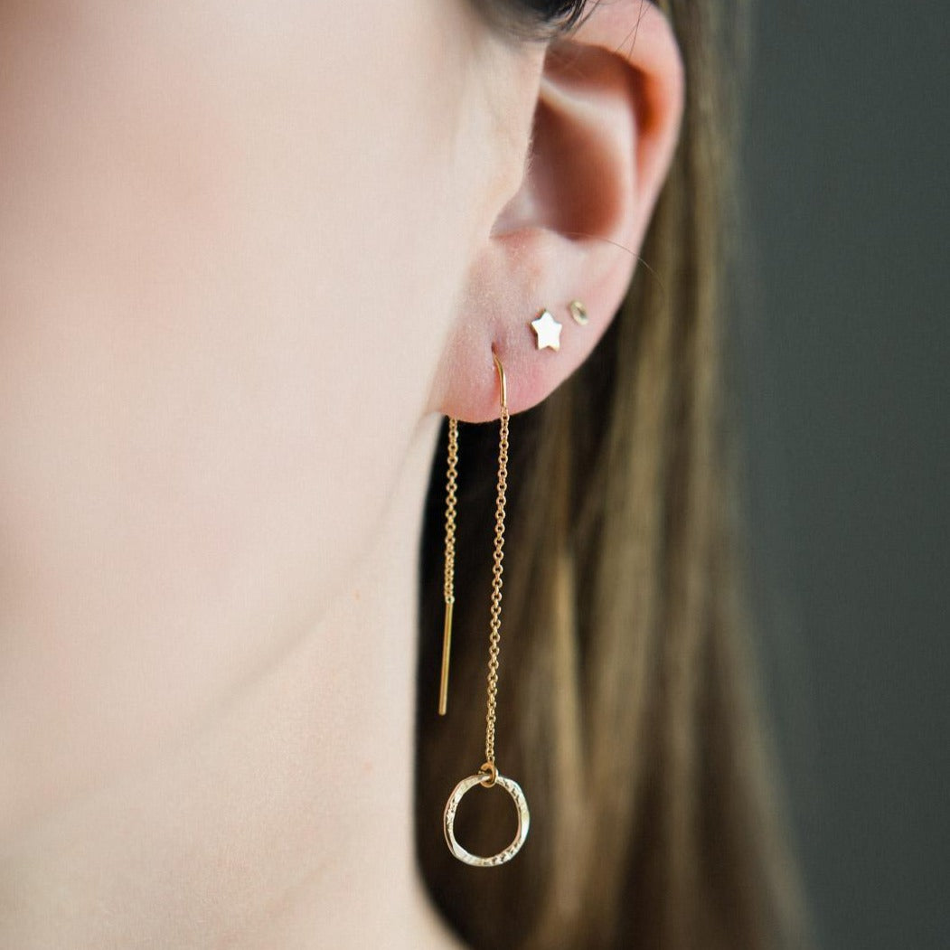 A pair of gold-filled full threader earrings with a small molten circle drop.