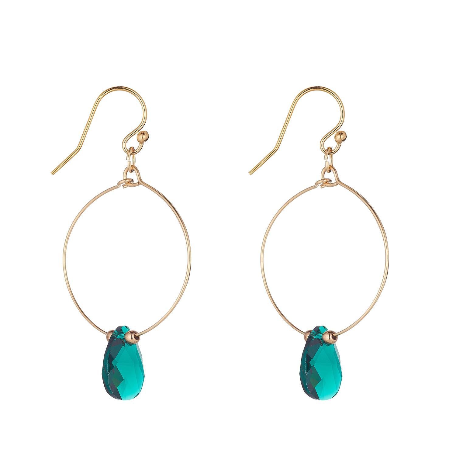 A pair of gold filled hoop earrings with emerald green crystal teardrop crystals.