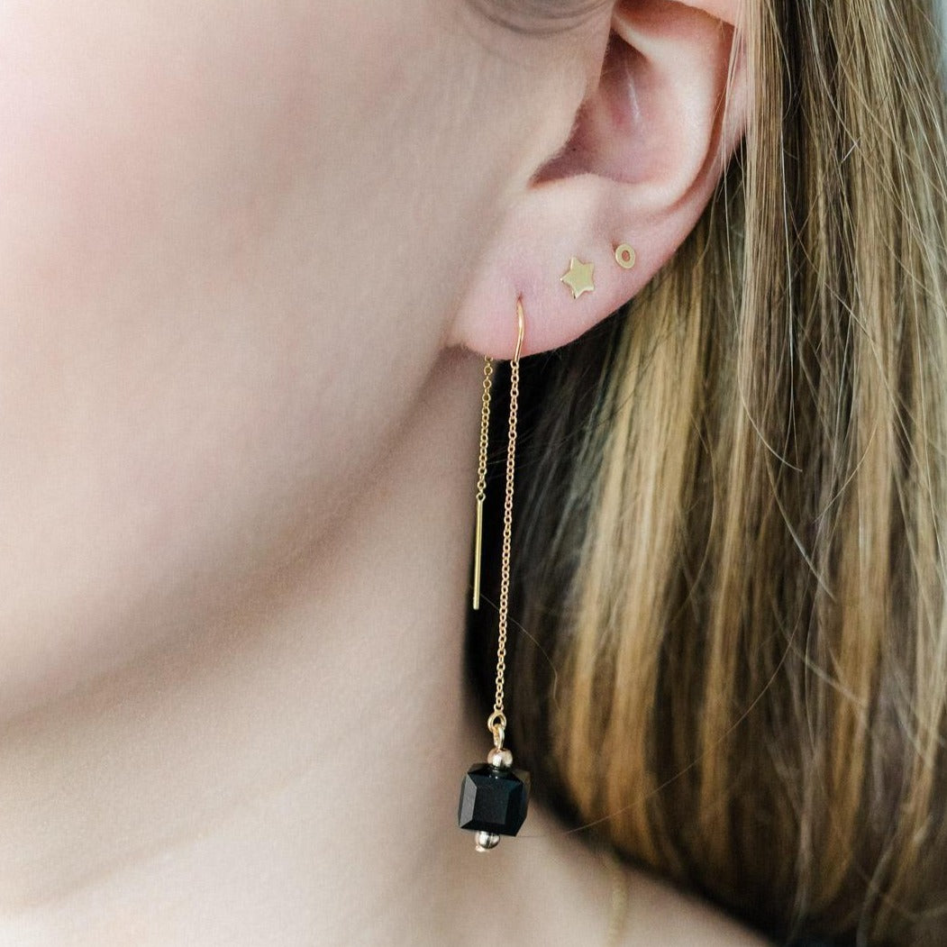 A pair of gold filled black crystal cube threader earrings.
