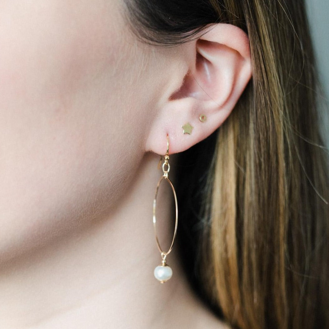 A pair of gold filled small hoop earrings with petite freshwater pearl.