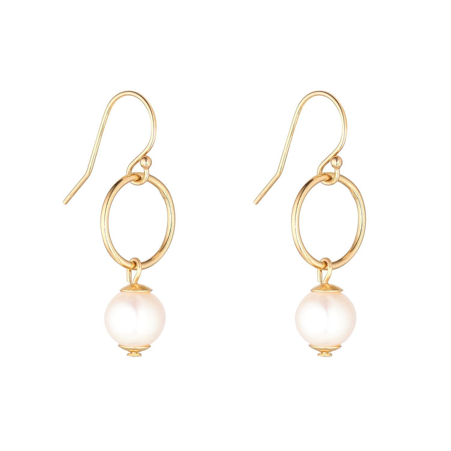 A pair of gold filled earrings featuring a small pearl drop and a circle link above the pearl.